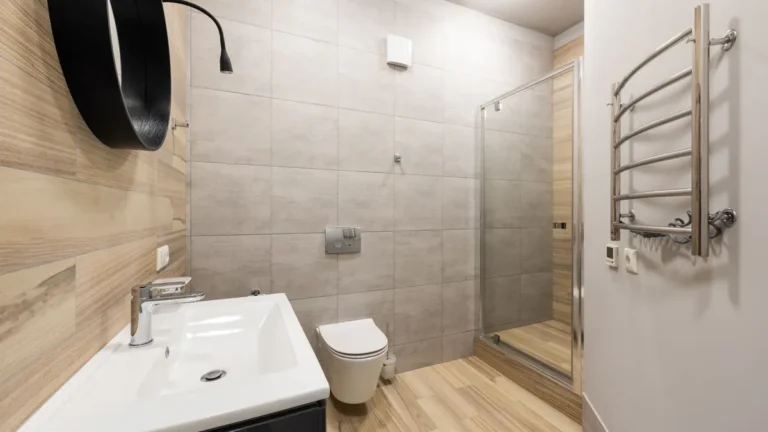 Moderne badkamer met grijze wandtegels, glazen douche en tegels met houtlook op de vloer