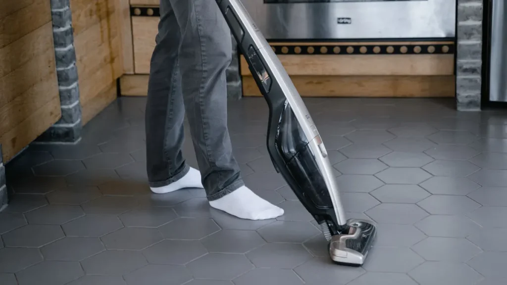 Steelstofzuiger op een grijze zeshoekige tegelvloer in een keuken